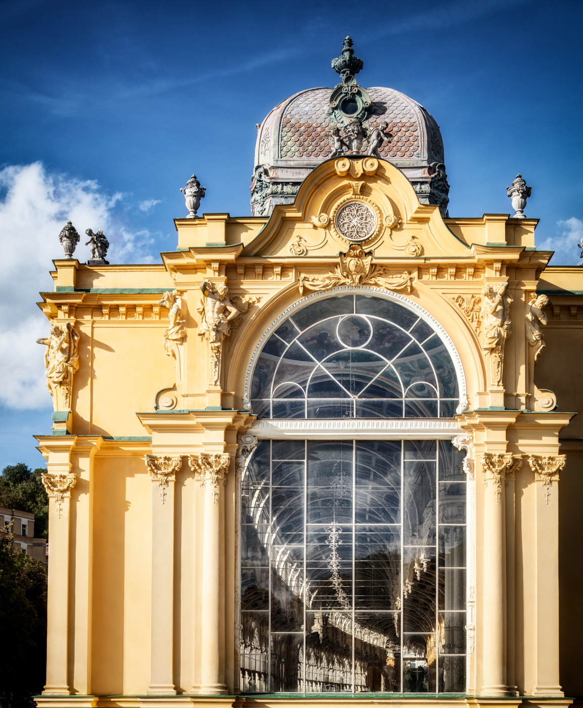 Gelber Endpavillon der Hauptkolonnade in Marienbad mit großem Glasfenster, Skulpturen und Kuppel
