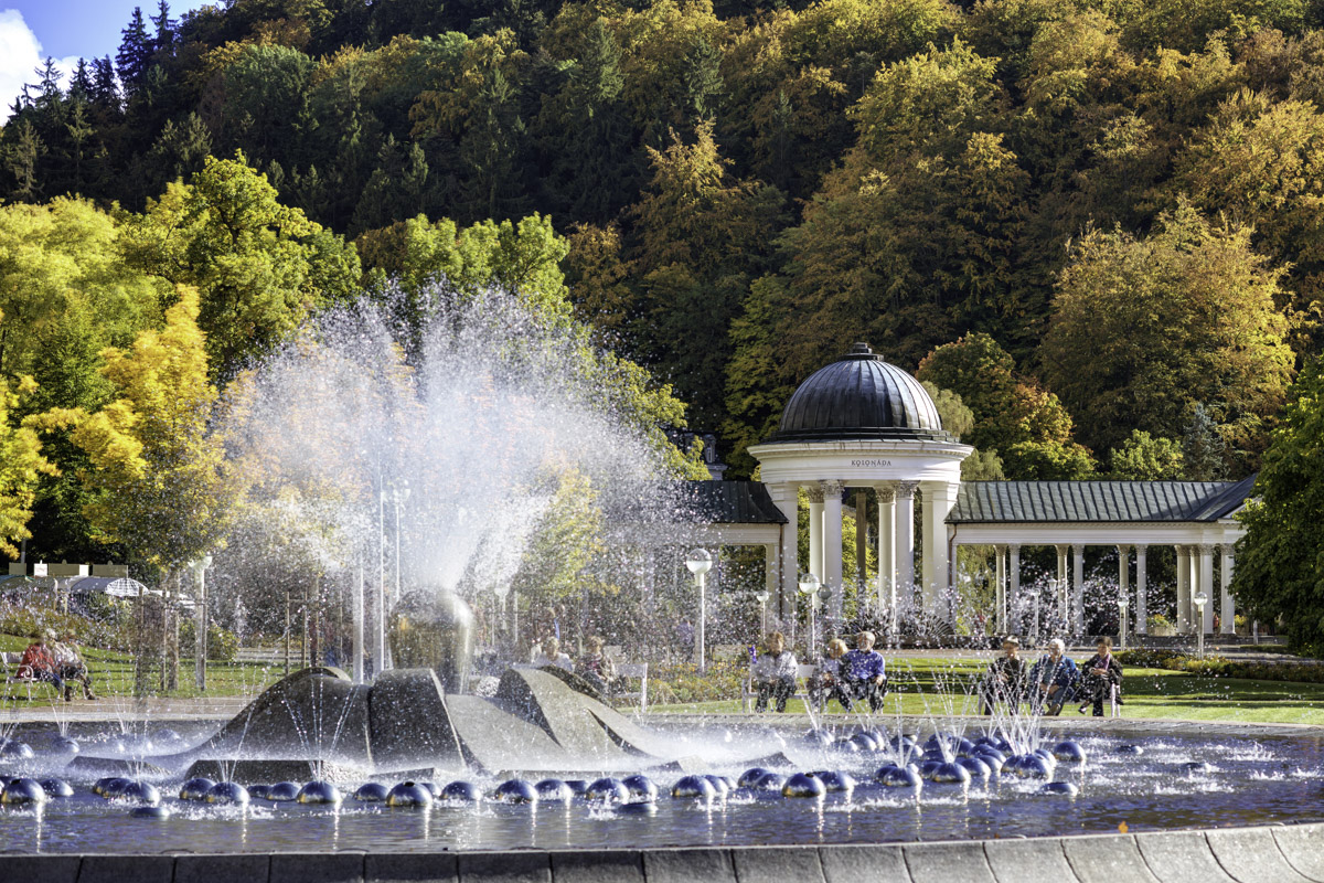 The Singing Fountain and its pavilion ringed by trees in autumn colour