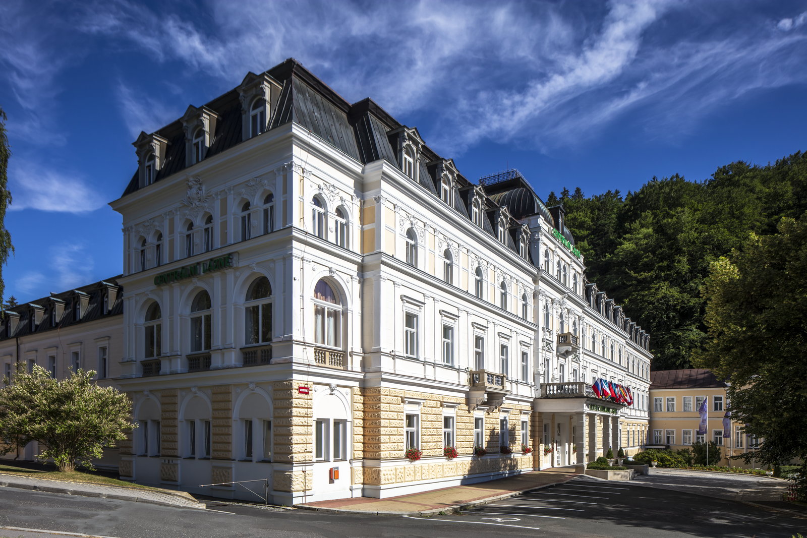 Neo-Baroque spa hotel with a steep mansard roof under a clear blue sky