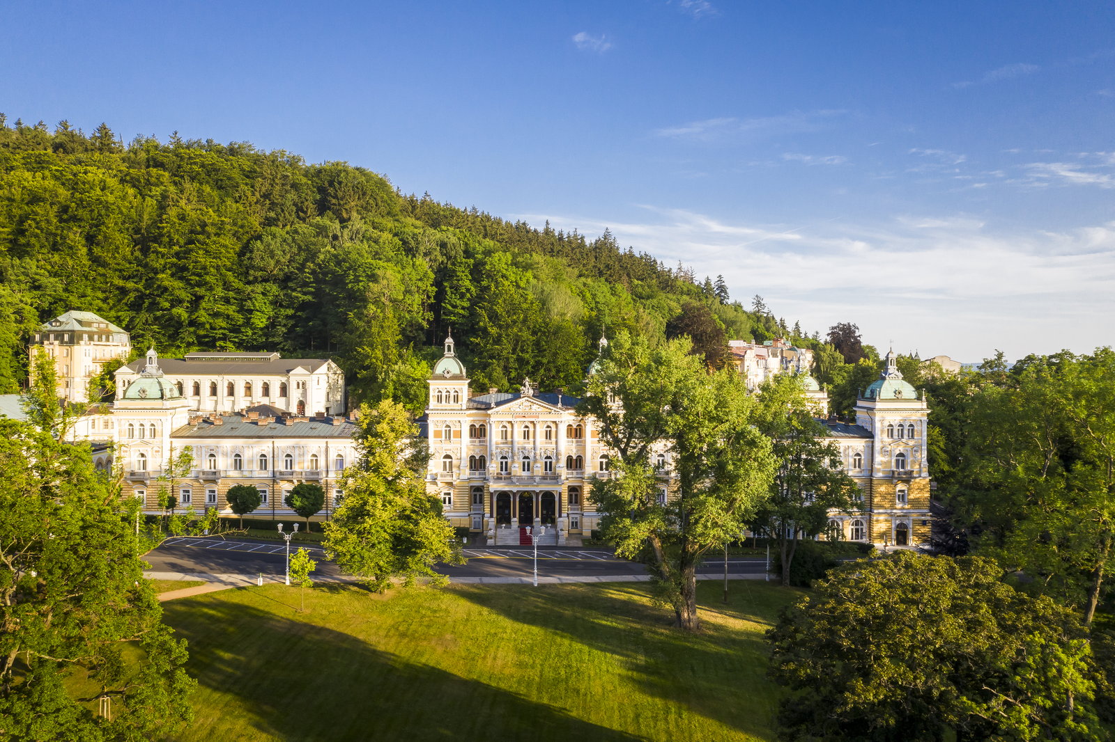 Blick auf die Kurhäuser vor einem bewaldeten Hang.