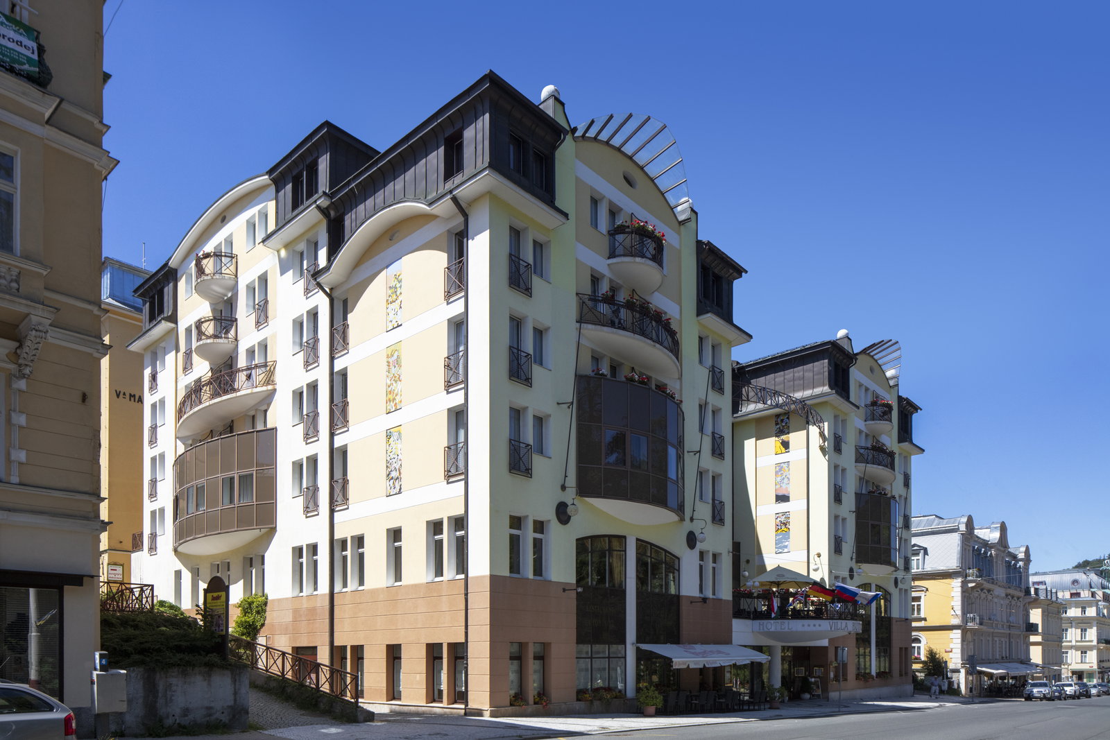 Corner townhouse with balconies and a ground-floor café