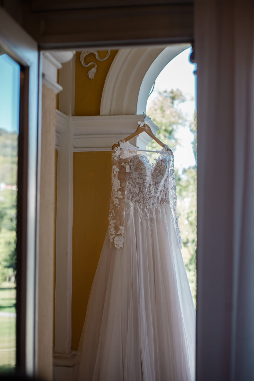 Das Brautkleid hängt in der Fensternische des Hotels